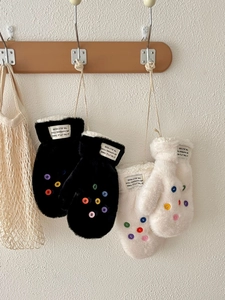 Details von Plüsch-Winterfäustlingen mit bunten Knöpfen und praktischem Umhängeband