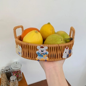 Detail of hand holding a woven fruit basket with animal patches and fresh lemons