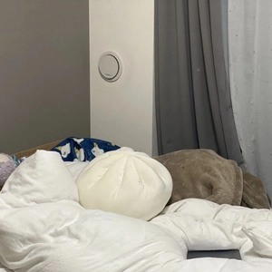 Detailed view of the soft pleated texture on a white dumpling-shaped plush pillow