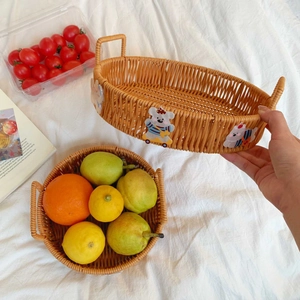 Detail of woven fruit baskets with cute bear accents and double handles on white cloth