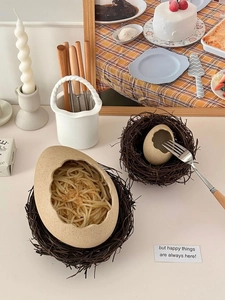 Macro view of bionic eggshell ceramic bowls with decorative woven bird nest bases