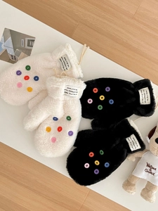 Nahaufnahme der flauschigen Winterfäustlinge mit bunten Knöpfen und weichem Kunstfell