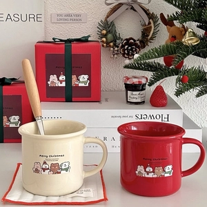 Close-up of Christmas ceramic mugs with cartoon animal prints and wooden metal spoons