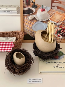 Detailed view of creative eggshell ceramic bowl with rustic twig bird nest base stand