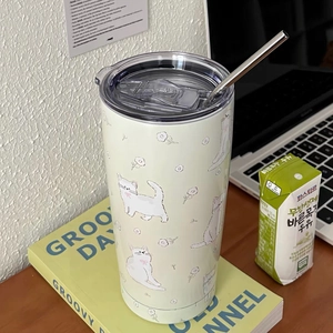 Detail of cream stainless steel tumbler with floral cat print and metal straw