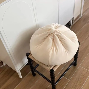 Creamy white steamed bun plush cushion on a rattan stool, soft velvet pillow for home decor