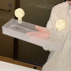 Detail view of the suction cup installation on a frosted plastic bathroom storage shelf