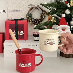 Close-up of festive Christmas bear ceramic mugs with wooden handle spoons in a cozy setting