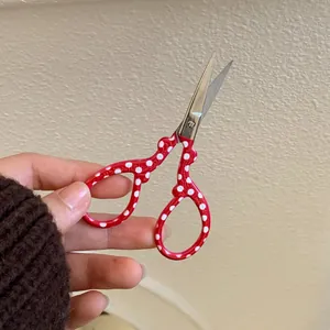 Macro shot of stainless steel scissors with red polka dot handle for precision sewing