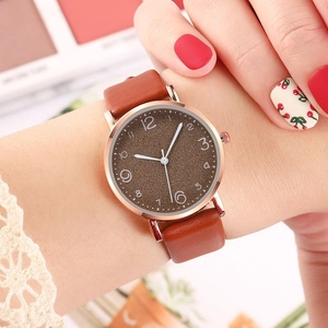 Elegant women's quartz watch with brown leather strap and rose gold case on wrist