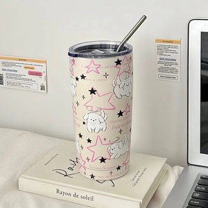Close-up of cream stainless steel tumbler with cute dog prints and metal straw