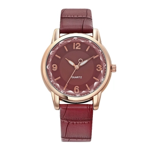 Detail of rose gold watch case with burgundy croc-pattern strap and quartz dial