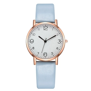 Detail of light blue leather strap and rose gold quartz watch with numeric dial