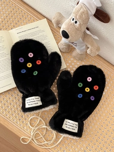 Detail von Plüschfäustlingen in Schwarz mit bunten Knöpfen und dickem Fleece-Futter