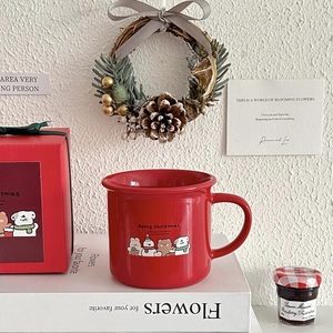 Close-up of red Christmas ceramic mug with Merry Christmas print and matching gift box