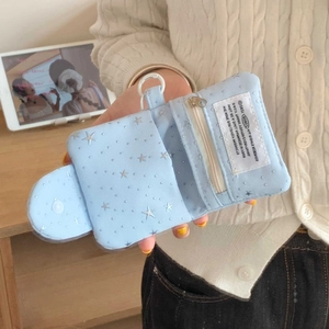 Close-up of star-patterned light blue mini card holder with zipper and white clip hook