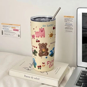 Detail of cute cartoon dog thermal cup with stainless steel straw on a desk