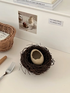Macro detail of a creative eggshell ceramic bowl inside a handmade twig bird nest
