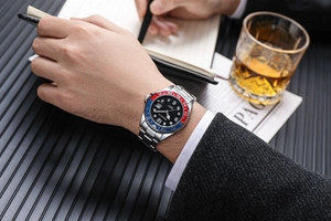Men's quartz watch with red and blue bezel on wrist in premium business setting