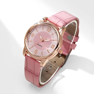 Detail view of pink leather strap and rose gold quartz watch dial for female students