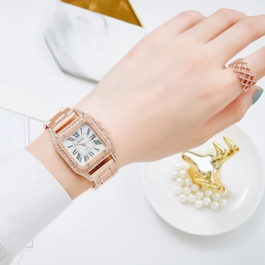 Dettaglio di un orologio quadrato oro rosa con lunetta in cristallo e numeri romani al polso