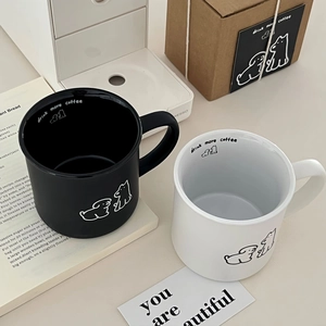 Gros plan de mugs en céramique noir et blanc minimalistes avec motifs de chien et anses larges