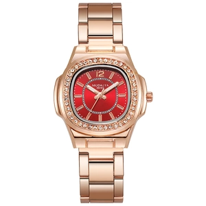 Close-up of rose gold watch with sunray red dial and diamond-set bezel detail