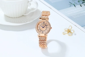 Dettaglio orologio di lusso in oro rosa con strass scintillanti su ghiera e cinturino