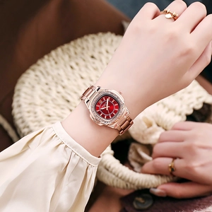 Macro detail of rose gold quartz watch with red sunray dial and rhinestone bezel