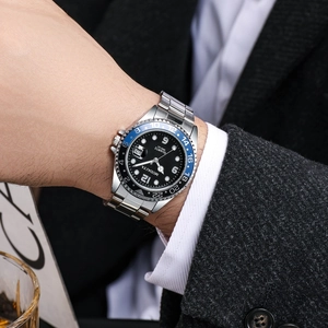 Detail of luxury men's quartz watch with blue and black rotating bezel and date window