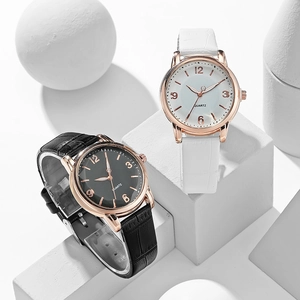 Detailed view of minimalist quartz watches with embossed leather straps on geometric props