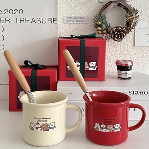 Christmas ceramic mugs set with Merry Christmas text, wooden spoons, and red gift boxes