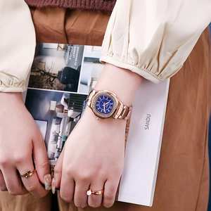 Elegant rose gold women's quartz watch with diamond bezel and blue dial on wrist