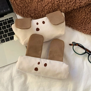 Close-up of cute canvas dog and rabbit pencil cases with corduroy ears on a cozy desk