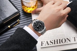 Detail of silver stainless steel men's watch with black GMT bezel and date window display