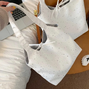 Close-up of star print canvas tote bag with striped lining and decorative bow detail