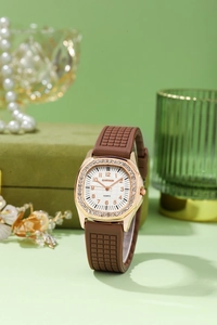 Close-up of Gadyson square rose gold watch with rhinestone bezel and brown rubber strap