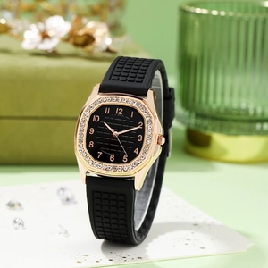 Detail of rose gold rhinestone watch with black rubber strap and textured dial
