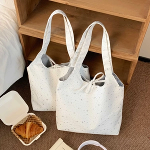 Detail of star pattern canvas tote bag with striped lining and drawstring closure