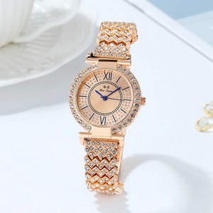 Dettaglio orologio da donna in oro rosa con lunetta di cristalli e cinturino a maglia