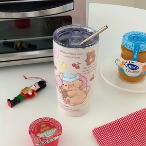 Close-up of cream stainless steel cup with cute puppy prints and metal straw detail