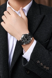 Nahaufnahme einer silbernen Quarz-Herrenuhr mit schwarzem Silikonarmband am Handgelenk