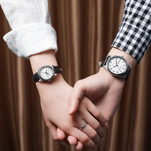 Couples quartz watches with white dial, leather strap, and date-day display on wrist