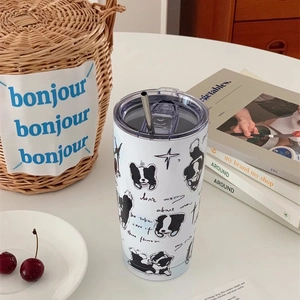Close-up of a white puppy thermal mug with a stainless steel straw in a lifestyle setting