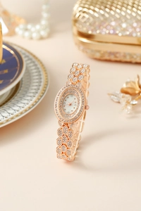 Dettaglio orologio al quarzo oro rosa con strass su sfondo di lusso con perle