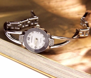 Dettaglio dell'orologio a bracciale argento con maglie a H e decorazioni in diamanti