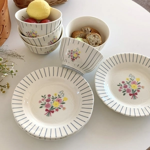 Detail of vintage French floral ceramic bowl with blue stripes and colorful bouquet pattern