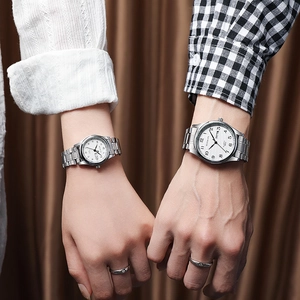 Fashion couple quartz watches with silver steel bands and date display on brown backdrop