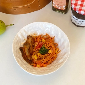 Detail of white ceramic noodle bowl with rock texture and homemade pasta dish