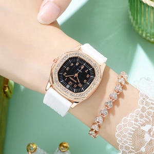Detail of luxury rhinestone square watch with white silicone strap and heart bracelet